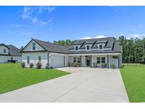 Charming two-story home with a manicured lawn, black roof, white exterior and inviting front porch at 1253 Kenworth Circle, Conway, SC 29526