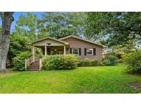 Charming brick home featuring a cozy front porch and a well-manicured lawn, surrounded by lush greenery at 1272 Park Hill Dr., Conway, SC 29526