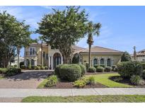 Stunning two-story home with a well-manicured lawn, mature trees, and a brick driveway at 1503 Cadiz Dr., Myrtle Beach, SC 29579