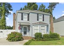 Charming two-story home featuring a well-manicured lawn, an American flag, and a welcoming front entrance at 1575 Victoria Ln., Myrtle Beach, SC 29577
