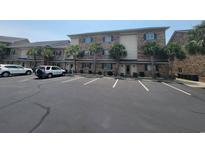 Multi-story condo with brick veneer and palm trees near the parking lot at 207 Double Eagle Dr. # E-1, Surfside Beach, SC 29575