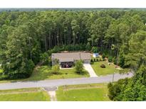 An aerial view of a quaint single-Gathering home nestled among mature trees and greenery, offering privacy at 2135 Starduster Ln., Little River, SC 29566