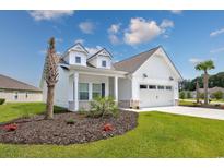 Charming white home with a well-manicured lawn, inviting curb appeal, and an attached two-car garage at 2143 Stonecrest Dr. Nw, Calabash, NC 28467