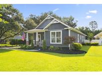 Charming home exterior featuring blue siding, a welcoming front porch with rocking chairs, and a lush green lawn at 2588 Long Avenue Ext., Conway, SC 29526