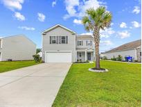 Charming two-story home featuring a well-manicured lawn and a driveway leading to an attached two-car garage at 317 Truce St., Myrtle Beach, SC 29588