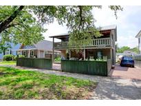 Charming two-story home featuring a cozy porch and balcony overlooking a landscaped yard at 325 Orange St., Georgetown, SC 29440