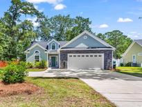 Charming two-story home featuring stone accents, manicured lawn, and a spacious two-car garage at 3864 Journeys End Rd., Murrells Inlet, SC 29576