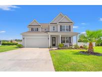 Charming two-story home with a well-manicured lawn and inviting front porch on a beautiful sunny day at 405 Spring View Ct., Little River, SC 29566