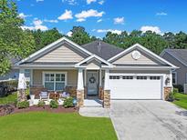 Charming single-story home with a well-manicured lawn, two-car garage and inviting front porch at 428 Arlington Circle, Murrells Inlet, SC 29576