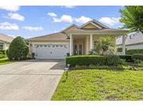 Inviting home with a two-car garage, landscaped yard, and charming front porch and partial driveway at 492 Grand Cypress Way, Murrells Inlet, SC 29576
