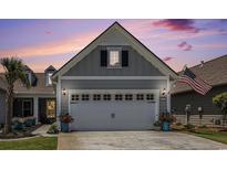 Attached two-car garage with flowerpots and an American flag at 5826 Cremona Dr., Myrtle Beach, SC 29577