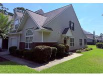 Charming home with beige siding, brick accents, manicured landscaping, and a well-maintained lawn at 62 4 Rye Grass Ln. # 4, Pawleys Island, SC 29585