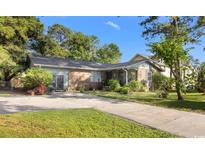 Charming single story home featuring a brick exterior and lush landscaping at 6210 Blynn Dr., Myrtle Beach, SC 29572