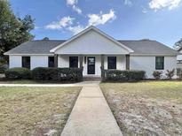 Charming one-story home with white brick, dark accents, and a well-maintained front yard at 7610 Driftwood Dr., Myrtle Beach, SC 29572