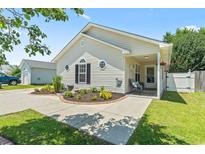 Charming one-story home featuring a landscaped front yard and inviting front porch seating at 1007 Autumn Dr., Murrells Inlet, SC 29576