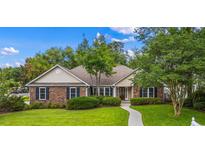 Charming brick home with manicured lawn, mature landscaping, and inviting walkway to front door at 104 Ashton Circle, Myrtle Beach, SC 29588