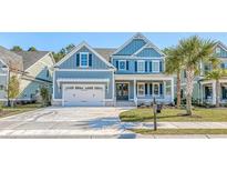 Charming two-story home featuring a manicured lawn, stylish shutters and a welcoming front porch with palm tree at 1054 East Isle Of Palms Ave., Myrtle Beach, SC 29579
