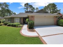 Charming single-story brick home with manicured landscaping and attached two-car garage at 112 Birchwood Ln., Conway, SC 29526