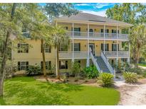Charming two-story home with a double front porch, landscaped yard, and blue skies at 1176 Old Plantation Dr., Pawleys Island, SC 29585