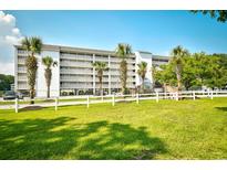 Beautiful condo with multiple balconies surrounded by lush landscaping and mature palm trees at 1425 Teague Rd. # 203, Myrtle Beach, SC 29577