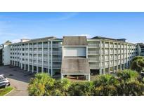 Exterior view of the multi-story condo building with a covered entrance and rows of private balconies at 14290 Ocean Hwy. # 407, Pawleys Island, SC 29585