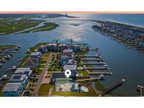 Stunning aerial view of waterfront home with private dock, pool and lush landscaping at 1510 North Shore Dr, Sunset Beach, NC 28468
