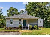 Charming single-story home featuring a teal front door, mature trees, and a well-maintained lawn at 3537 Lighthouse Way, Myrtle Beach, SC 29577