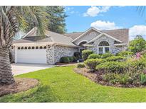 Charming home featuring a well-manicured lawn, beautiful landscaping, and an attached two-car garage at 4703 Bermuda Way, Myrtle Beach, SC 29577