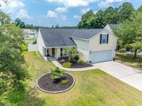 Inviting home featuring lush landscaping, a well-manicured lawn, and an attached one car garage at 805 Cherry Bark Ct., Myrtle Beach, SC 29579
