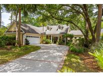 Stunning home featuring lush landscaping, a circular driveway, and a charming yellow exterior at 81 Prestwick Dr., Pawleys Island, SC 29585