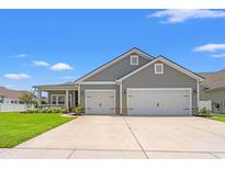 Charming single-Gathering home with a two-car garage, manicured lawn, and inviting front porch on a sunny day at 892 Harrison St., Myrtle Beach, SC 29579