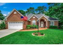 Charming brick home with an arched entry, brick walkway, beautiful lawn and two car garage at 911 Tilghman Forest Dr., North Myrtle Beach, SC 29582