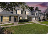 Charming townhome with green shutters and well-manicured lawn at dusk at 106 Scotch Broom Dr. # 105, Little River, SC 29566