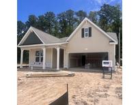 A charming one-story home under construction, featuring a two-car garage and inviting front porch at 1115 Rosefield Way, Calabash, NC 28467