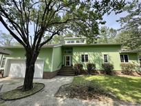 Charming single-story home boasts a light-green exterior with brick accents and a well-maintained front yard at 116 Capt Anthony White Ln., Georgetown, SC 29440