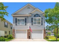 Charming two-story home featuring a double garage, and an inviting front yard at 1415 Powhaton Dr., Myrtle Beach, SC 29577