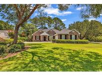 Charming single-story brick home with lush green lawn and mature trees in a desirable neighborhood at 1788 Club Circle, Pawleys Island, SC 29585