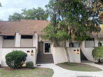 Charming townhome featuring a classic design and inviting front entrance with mature landscaping at 18 Canvas Back Cove # 122, Georgetown, SC 29440