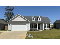 Charming single-Gathering home featuring a two-car garage, dormer windows, and manicured front lawn at 2594 W Shore Dr., Longs, SC 29568