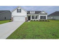 Charming two-story home features a manicured lawn, two-car garage and a welcoming front porch at 311 Six Mile Creek Dr., Georgetown, SC 29440