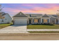 Charming single-story home featuring a two-car garage, well-manicured lawn and beautiful front yard landscaping at 3231 Little Bay Dr., Conway, SC 29526