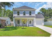 Charming two-story home with a manicured lawn, covered porch, and attached garage at 4329 Landing Rd., Little River, SC 29566