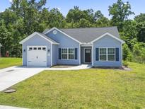 Charming single-story home with light blue siding, a well-manicured lawn, and an attached one-car garage at 437 Shallow Cove Dr., Conway, SC 29527