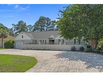 Charming one-story home with an expansive driveway, manicured lawn, and mature trees at 4709 National Dr., Myrtle Beach, SC 29579