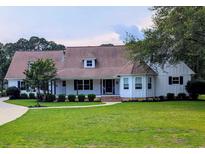Charming single-story home featuring a well-manicured lawn, complemented by mature trees and meticulous landscaping at 4719 National Dr., Myrtle Beach, SC 29579