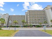 Large tan condo building with multiple stories, palm trees, and parking at 4719 S Ocean Blvd. # 108, North Myrtle Beach, SC 29582