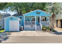 Charming beach cottage featuring a cozy porch and light blue siding at 6001 - Q21 South Kings Hwy., Myrtle Beach, SC 29575