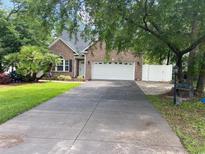 Charming brick home featuring an attached garage and a well-manicured lawn at 618 Cypress Dr., Surfside Beach, SC 29575
