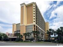 Spacious resort featuring an abundance of windows and a well-manicured lawn with mature palm trees at 6900 N Ocean Blvd. # 834, Myrtle Beach, SC 29577