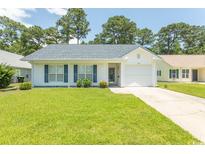 Charming single-story home featuring a well-manicured lawn and a classic white exterior at 123 Retreat Pl., Little River, SC 29566